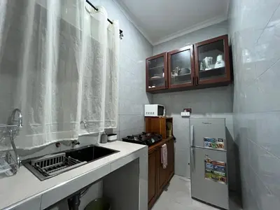 a small kitchen with a sink and a refrigerator at Nyumbani Nyumbani in Arusha