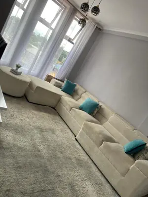 a large couch in a living room with blue pillows at QD Apartment in Arusha