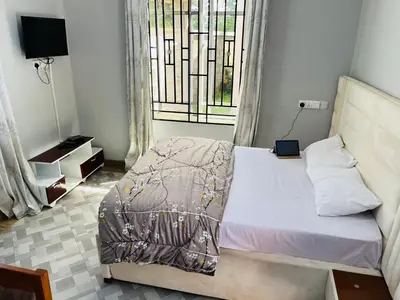a small bedroom with a bed with a window at leo apartment in Arusha