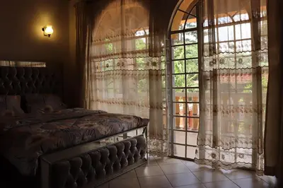 a bedroom with a bed and a large window at Madalina's Appartment in Arusha