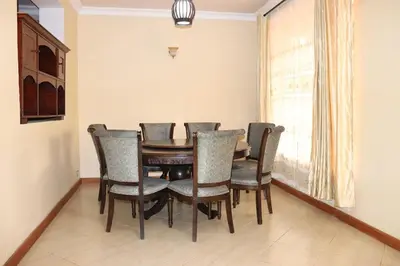 a dining room with a table and chairs at Madalina's Appartment in Arusha