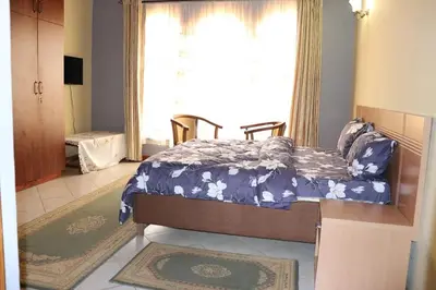 a bedroom with a bed in front of a window at Madalina's Appartment in Arusha