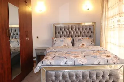 a bedroom with a large bed with a large headboard at Madalina's Appartment in Arusha