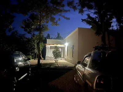 a car parked in front of a house at night at Lively Cottages Momella,Main House in Usa River