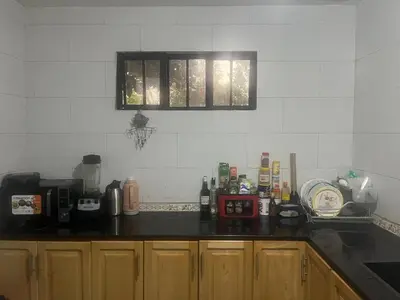 a kitchen with a black counter top and a window at Lively Cottages Momella,Main House in Usa River