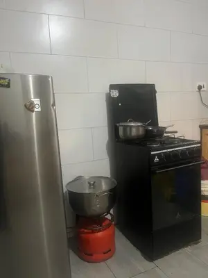 a kitchen with a stove and two pots and pans at Lively Cottages Momella,Main House in Usa River