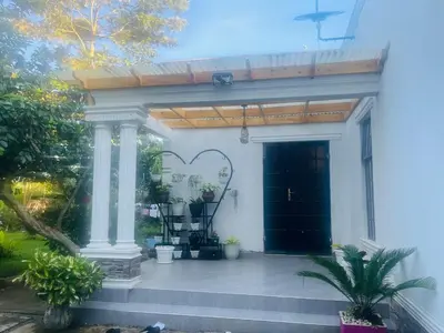 a entry to a house with a porch with a door at Lively Cottages Momella,Main House in Usa River