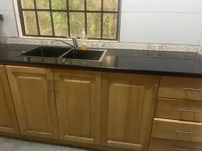 a kitchen counter with a sink and a window at Lively Cottages Momella,Main House in Usa River