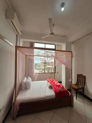 a bedroom with a canopy bed with a window at Twiga Hotel - Tulivu Urban in Moshi