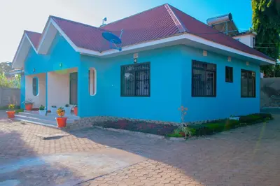 a blue house with a red roof at D&G Homes Apartments in Arusha