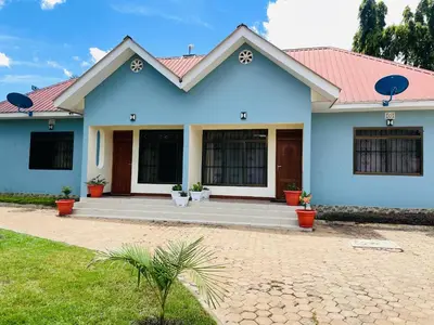 a blue house with a red roof at D&G Homes Apartments in Arusha