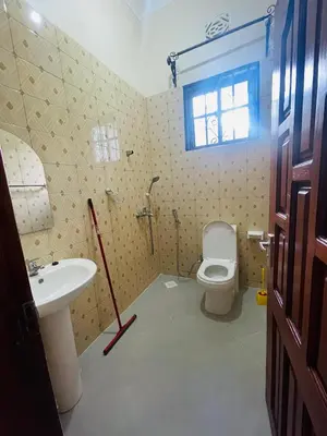 a bathroom with a sink and a toilet and a window at D&G Homes Apartments in Arusha