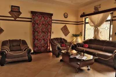 a living room with couches and chairs and a table at Msovi House in Arusha