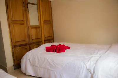 a red bow sitting on top of a white bed at Msovi House in Arusha