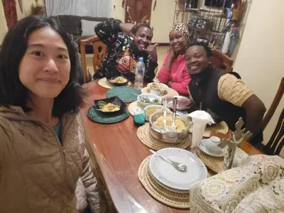 a group of people sitting around a table eating food at Msovi House in Arusha