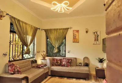 a living room with a couch and two windows at MSOVI Nest in Arusha