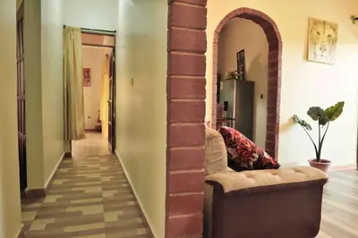 a living room with a brick pillar and a couch at MSOVI Nest in Arusha