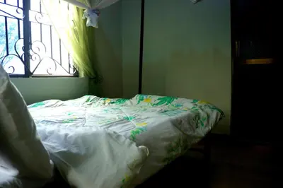 an unmade bed in a room with a window at MSOVI Nest in Arusha