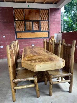 a wooden table and chairs sitting next to a brick wall at Makahawani Farmhouse in Arusha