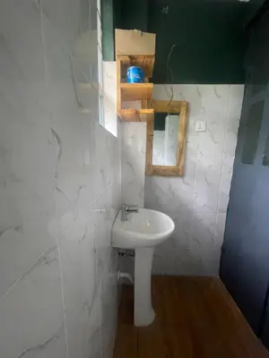 a bathroom with a white sink and a mirror at Makahawani Farmhouse in Arusha