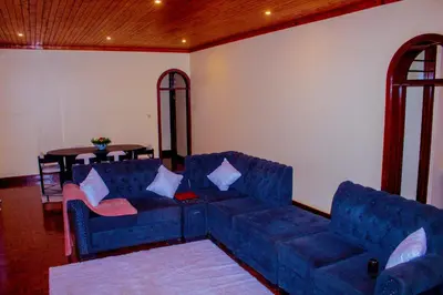 a living room with a blue couch and a table at Safari dwells apartment in Arusha
