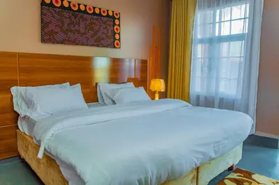 a large white bed in a room with a window at Geni's Villa & Spa Arusha in Arusha