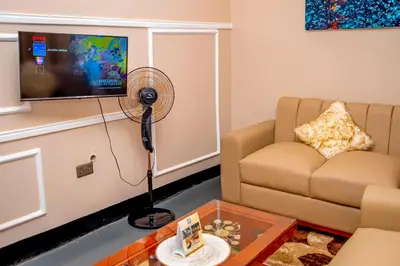 a living room with a couch and a fan at Geni's Villa & Spa Arusha in Arusha