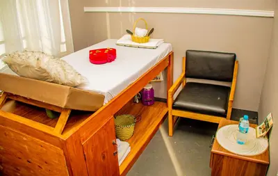 a bed and a chair in a room at Geni's Villa & Spa Arusha in Arusha