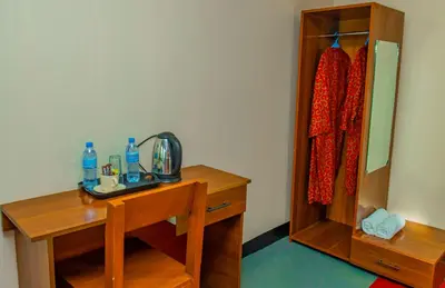a bathroom with a wooden desk and a mirror at Geni's Villa & Spa Arusha in Arusha