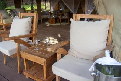 a couple of chairs and a table with wine glasses at Africa Safari Manyara Escarpment in Mto wa Mbu