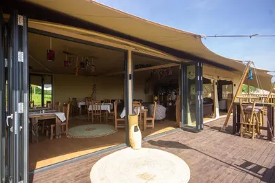 a covered patio with a table and chairs at Africa Safari Manyara Escarpment in Mto wa Mbu