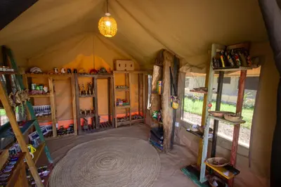 an inside view of a tent with shelves and a rug at Africa Safari Manyara Escarpment in Mto wa Mbu