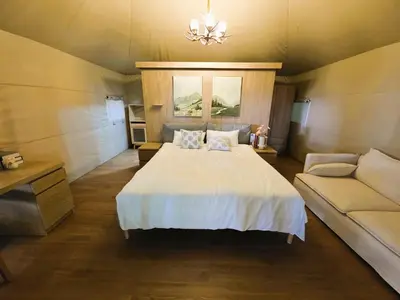 a bedroom with a white bed and a couch at Africa Safari Manyara Escarpment in Mto wa Mbu