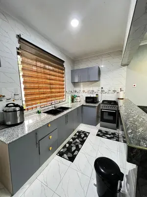 a kitchen with marble counter tops and a window at Hadraj Moshono Apartment2 in Arusha