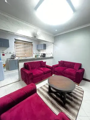 a living room with red couches and a table at Hadraj Moshono Apartment2 in Arusha