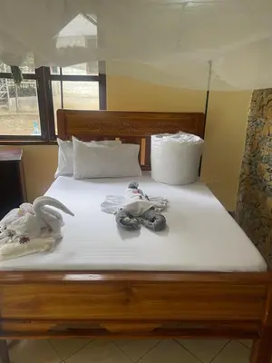 a bed with two pairs of shoes on it at Emanyatta Lodge in Monduli