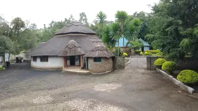 a small hut with a thatched roof in a yard at Emanyatta Lodge in Monduli