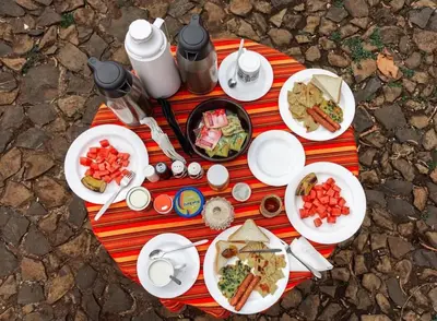 a picnic table with plates of food on it at Emanyatta Lodge in Monduli