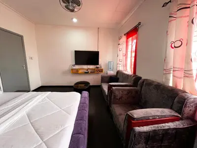 a hotel room with a couch and a tv at Hadraj Sokokuu Apartment2 in Arusha