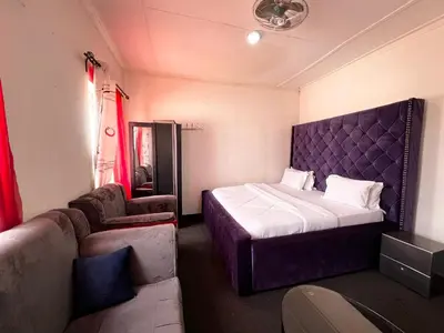 a small bedroom with a bed and a couch at Hadraj Sokokuu Apartment2 in Arusha