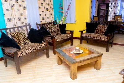 a living room with three chairs and a coffee table at Rosemo villa in Nduruma Chini