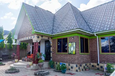 a brick house with a metal roof at Rosemo villa in Nduruma Chini