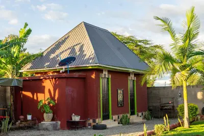 a red house with a black roof at Rosemo villa in Nduruma Chini