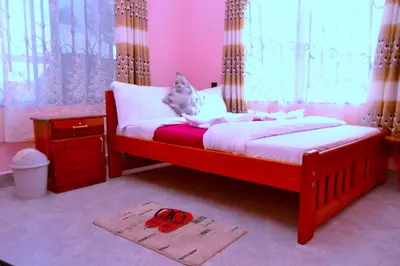 a bedroom with a bed with a red pair of scissors on the floor at The Hill Villas House in Arusha