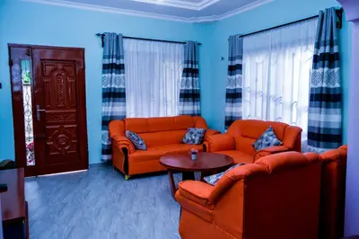 a living room with two orange couches and a table at The Hill Villas House in Arusha