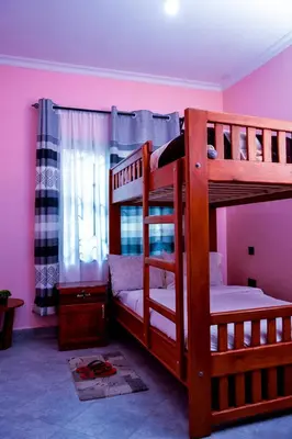 two bunk beds in a room with pink walls at The Hill Villas House in Arusha