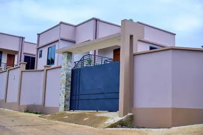 a pink house with a blue gate at Penthouse Moshono in Nkoanrua