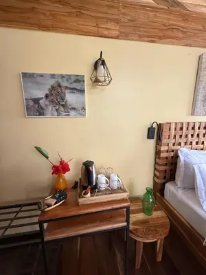 a room with a bed and a table with a table sidx sidx at Moyoni Africa Lodge & Tours in Arusha