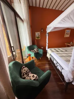 a bedroom with a bed and a dog laying in a chair at Moyoni Africa Lodge & Tours in Arusha