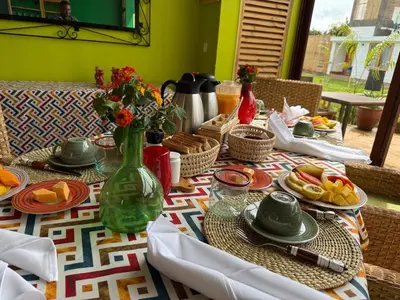 a table with plates of food and a vase with flowers at Moyoni Africa Lodge & Tours in Arusha